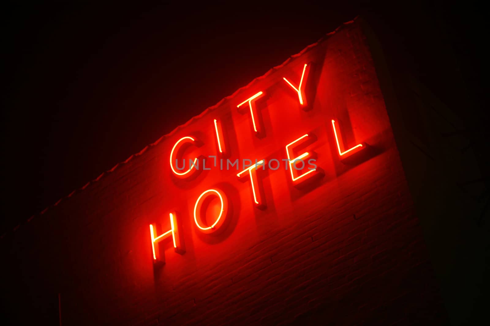 Foggy evening with neon sign saying City Hotel.