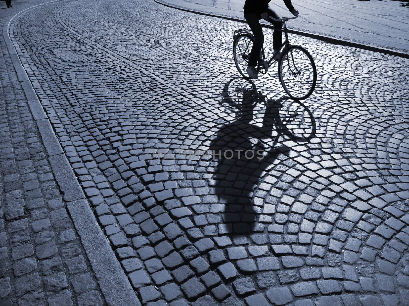  A warm spring afternoon a young man is biking through the old streets of Copenhagen, Denmark.                      