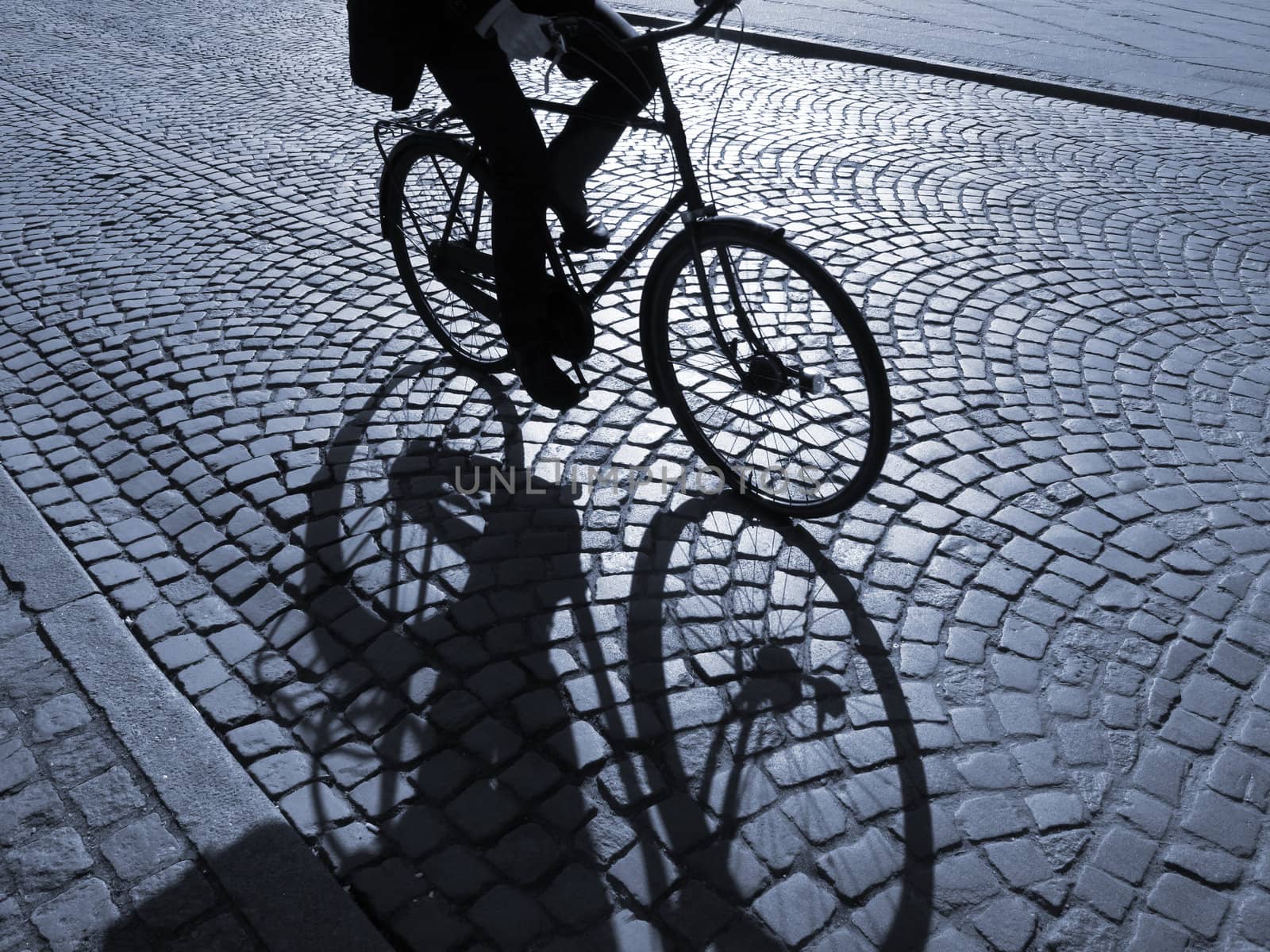  A warm spring afternoon a young man is biking through the old streets of Copenhagen, Denmark.                      