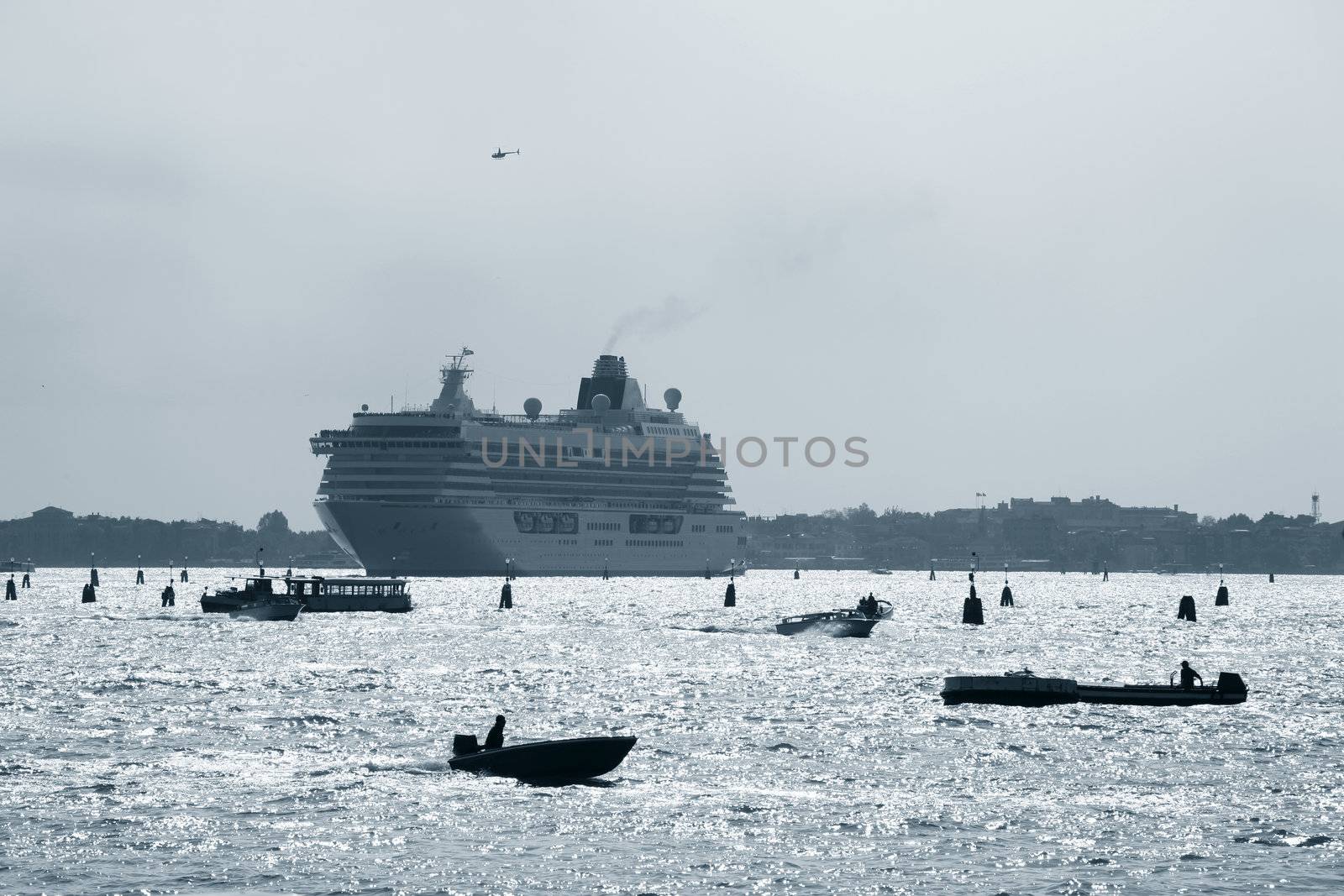 Heavy traffic outside the city of Venice - Italy. Cruise liner, chopper, ferry, taxi and transport wessels around each other in the lagoon.
