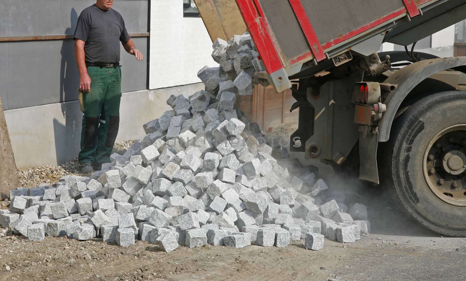 Lorry unloading cobblestones for new pavement.