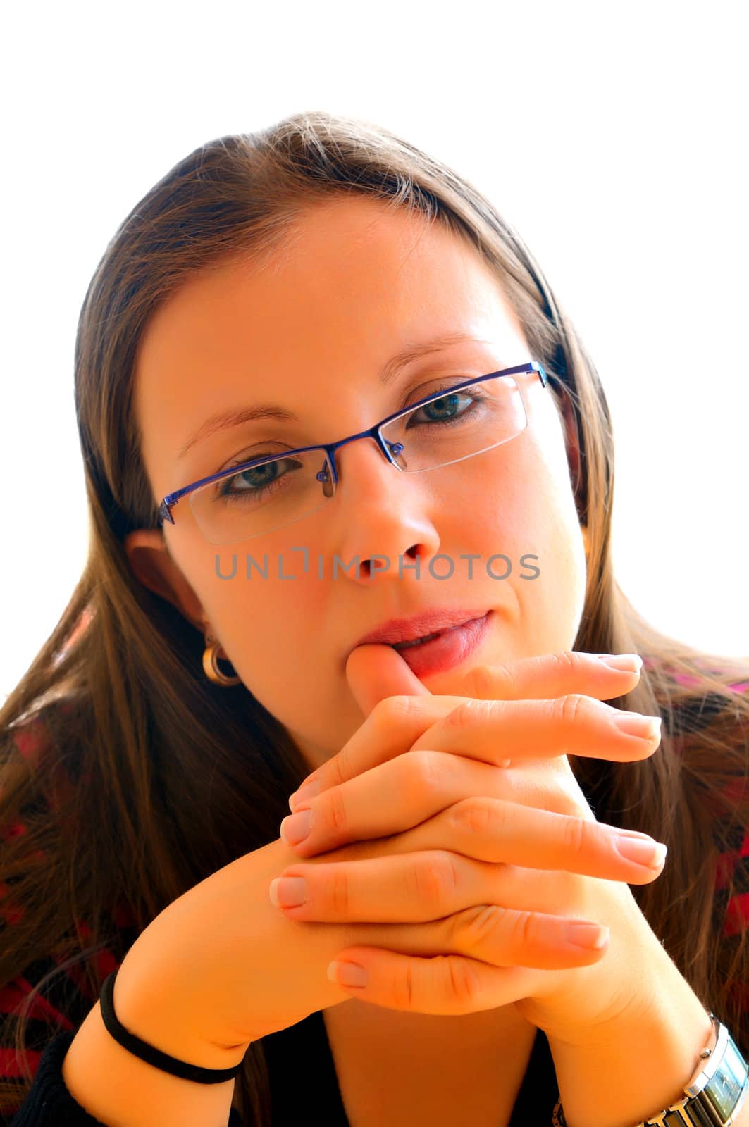Portrait of a beautiful girl with glasses who clasped her hands and looks straight at the photographer