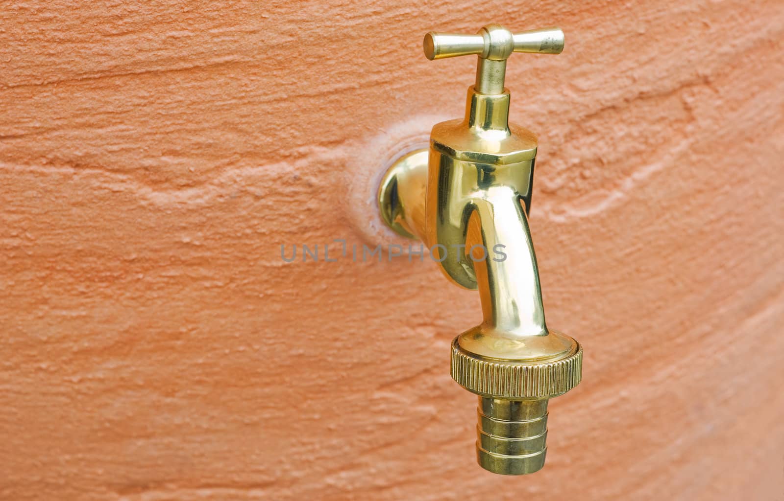 Old brass  Water Tap Against A  Wall 