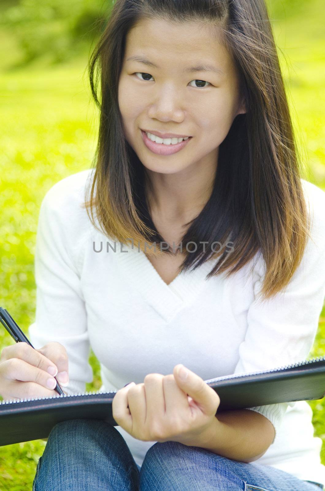 Asian student studying and writing at outdoors