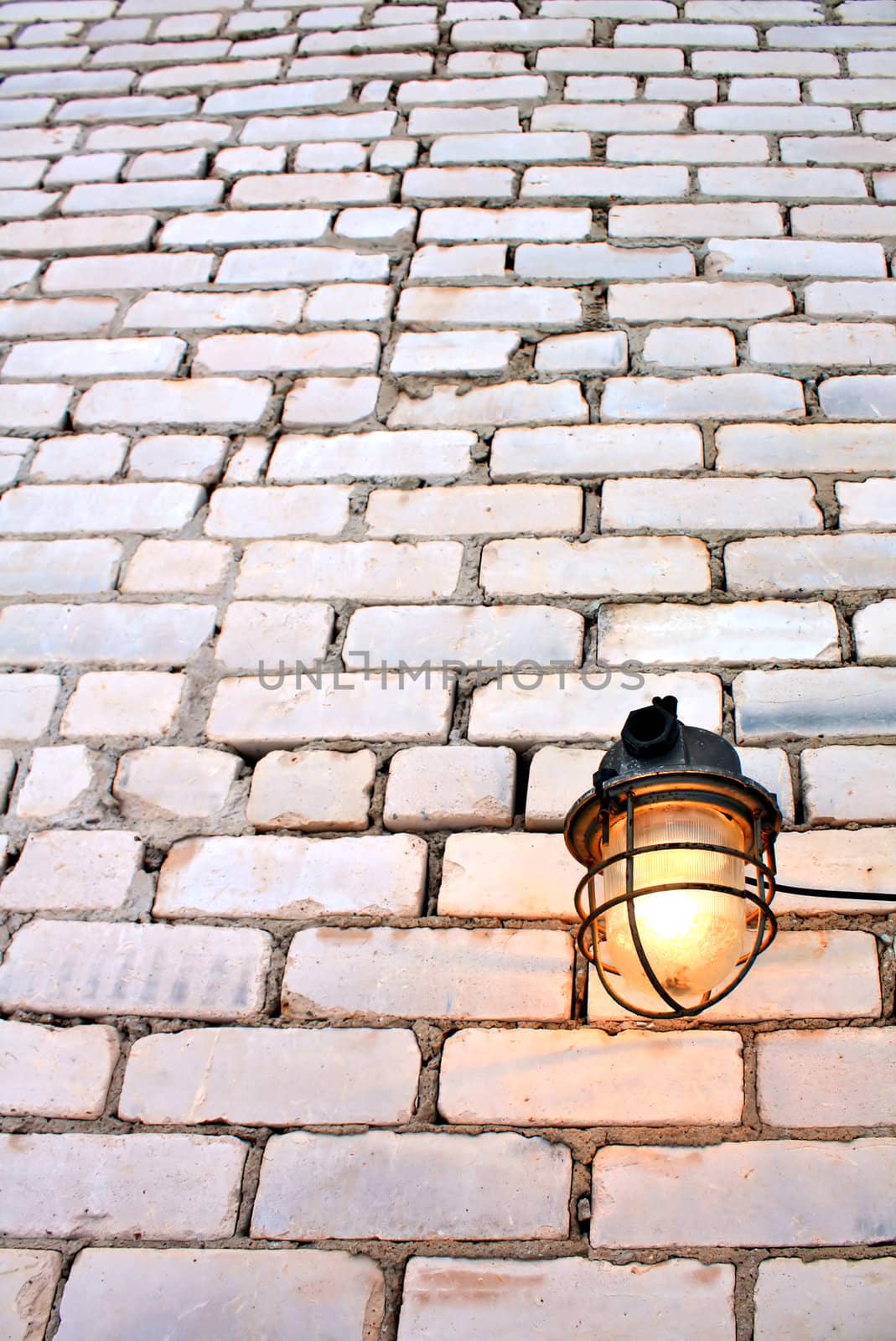 aging lamp on brick wall