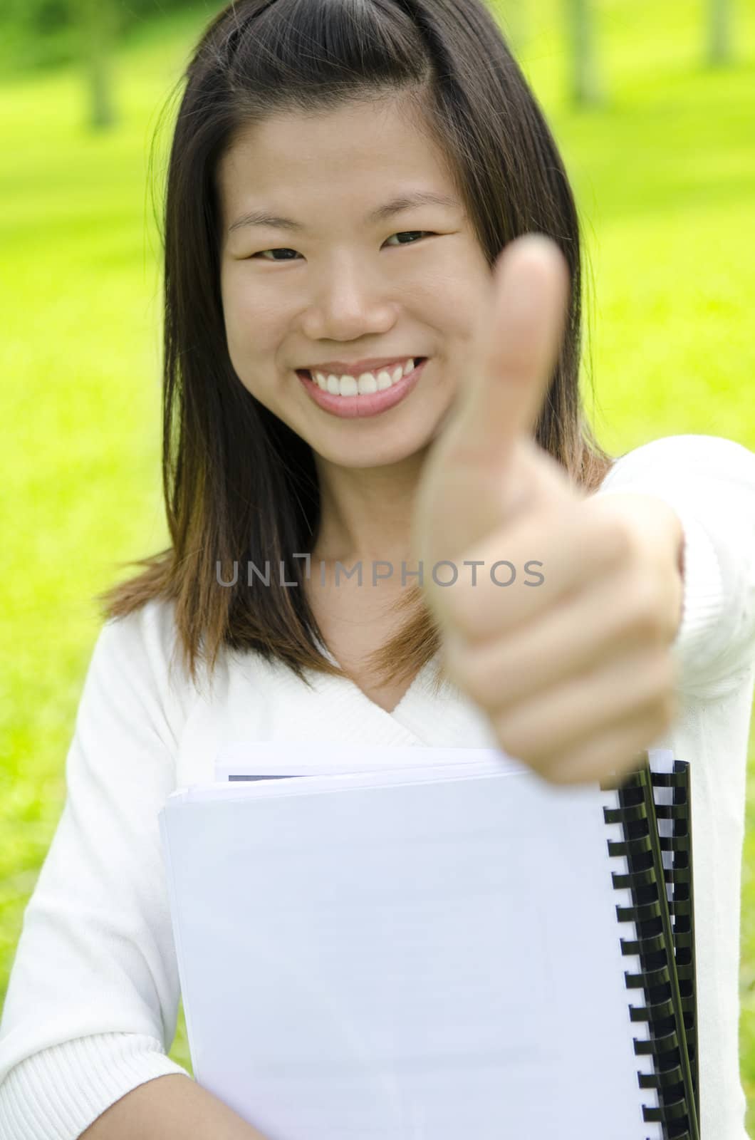 Female student thumbs up with great smile.