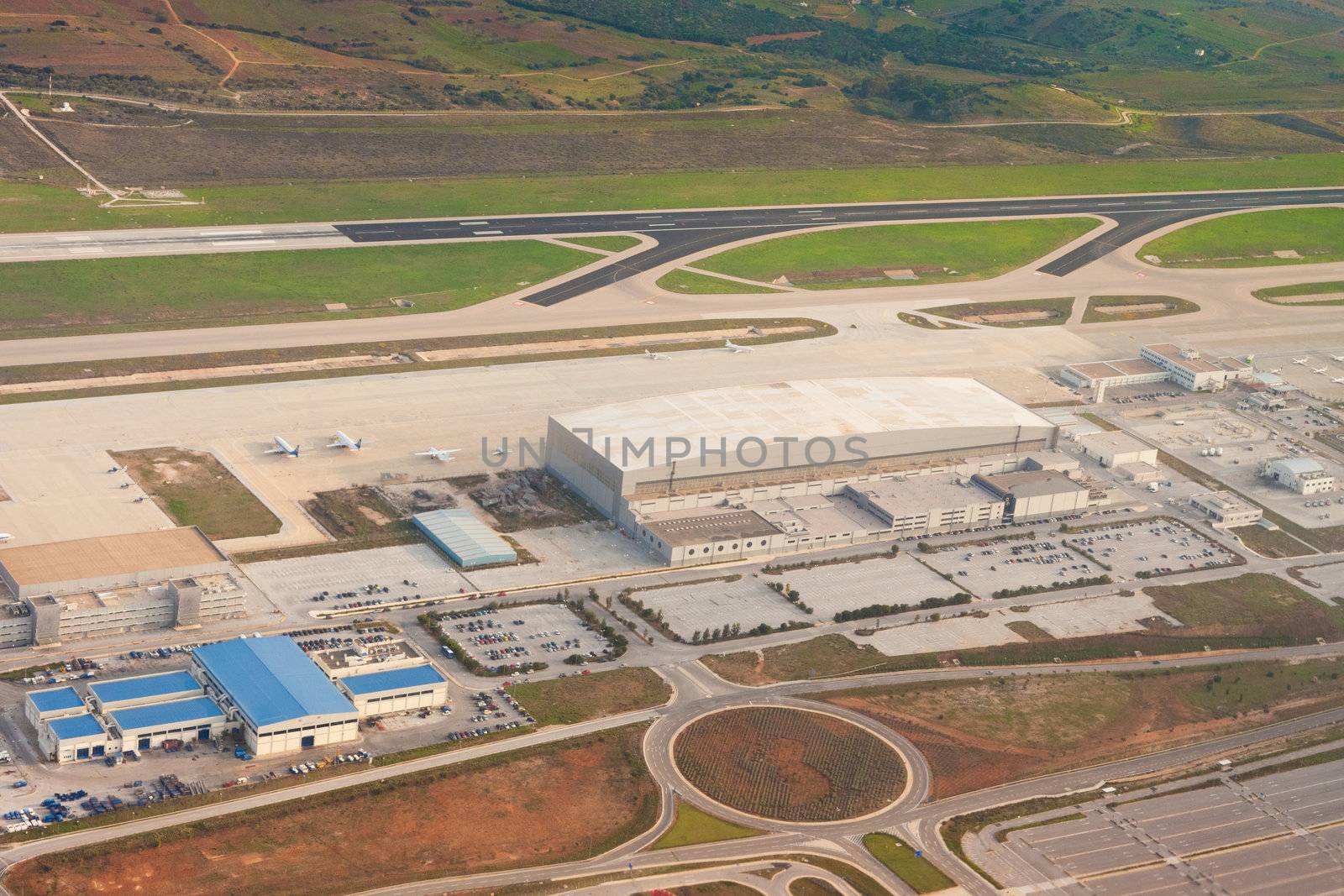 Aerial view of airport buildings, runways, taxiways, parking lots, airplane hangars and other infrastructure in Athens, Greece, Europe.