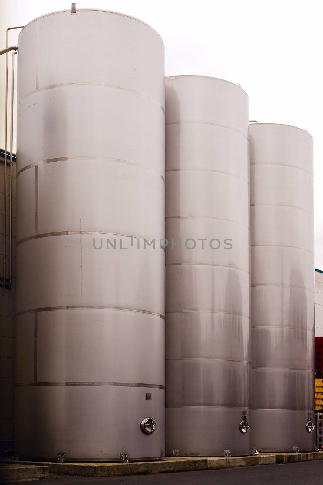 Three stainless steel tanks for storing beverages at bottle filling plant.