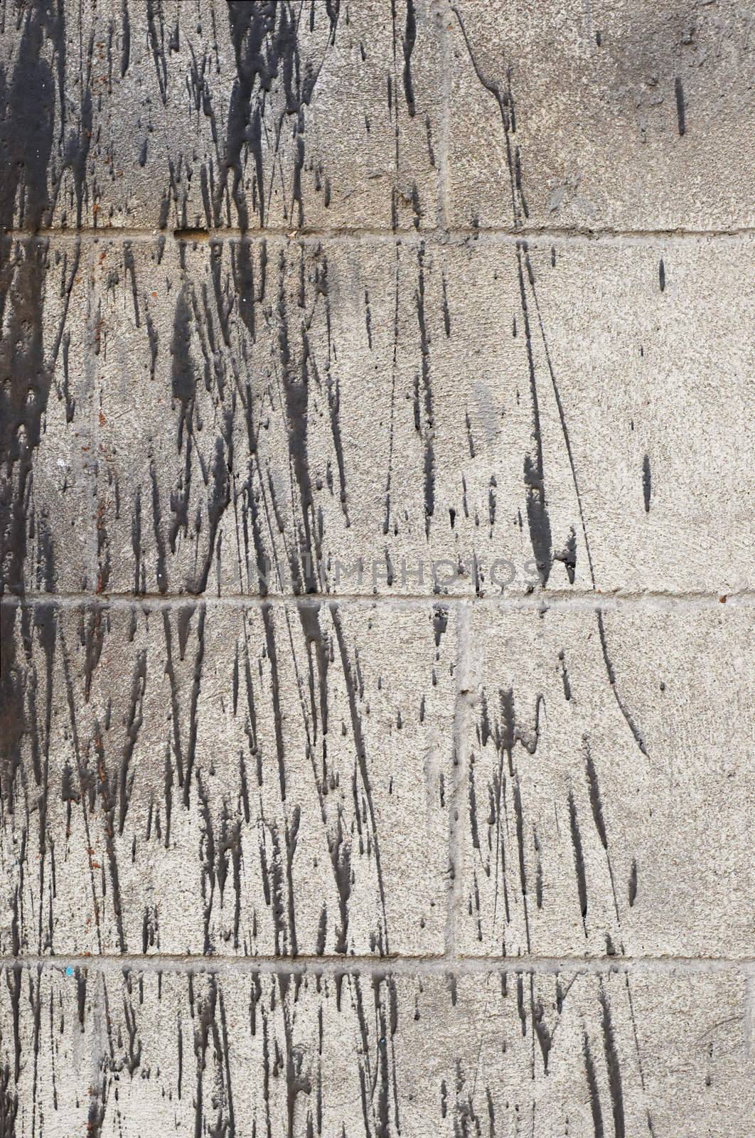 grunge background: bitumen splashes on concrete brick wall