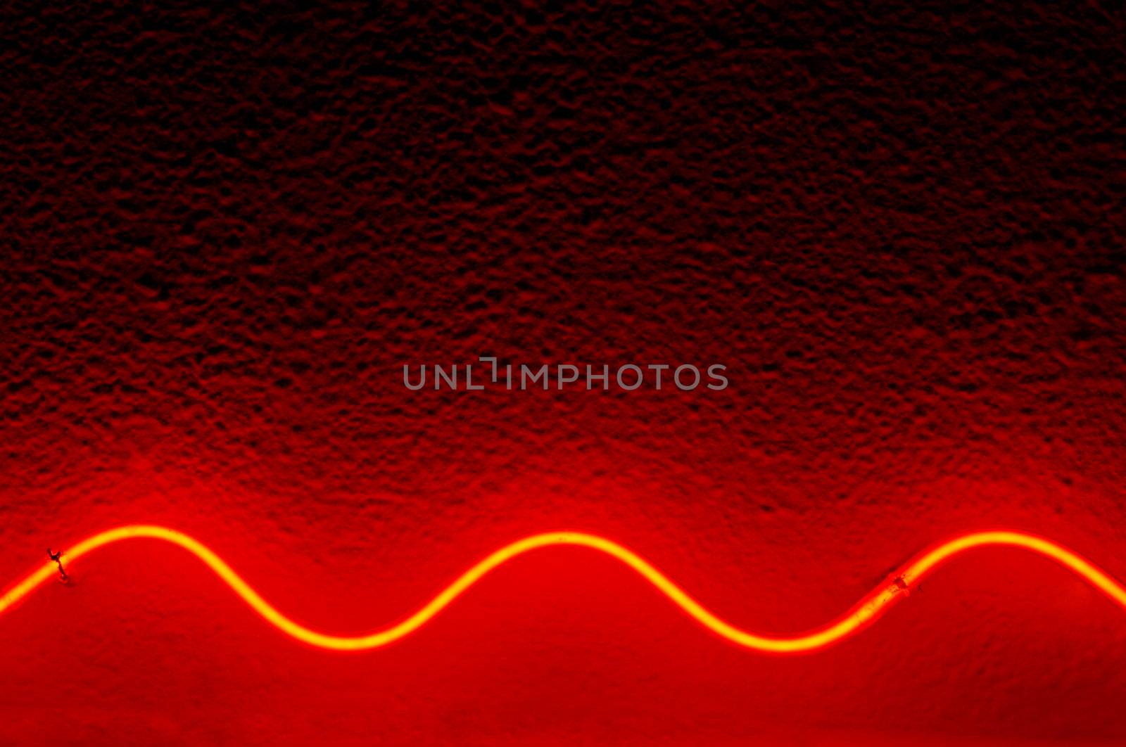 Red waved neon lamp light on stucco surface