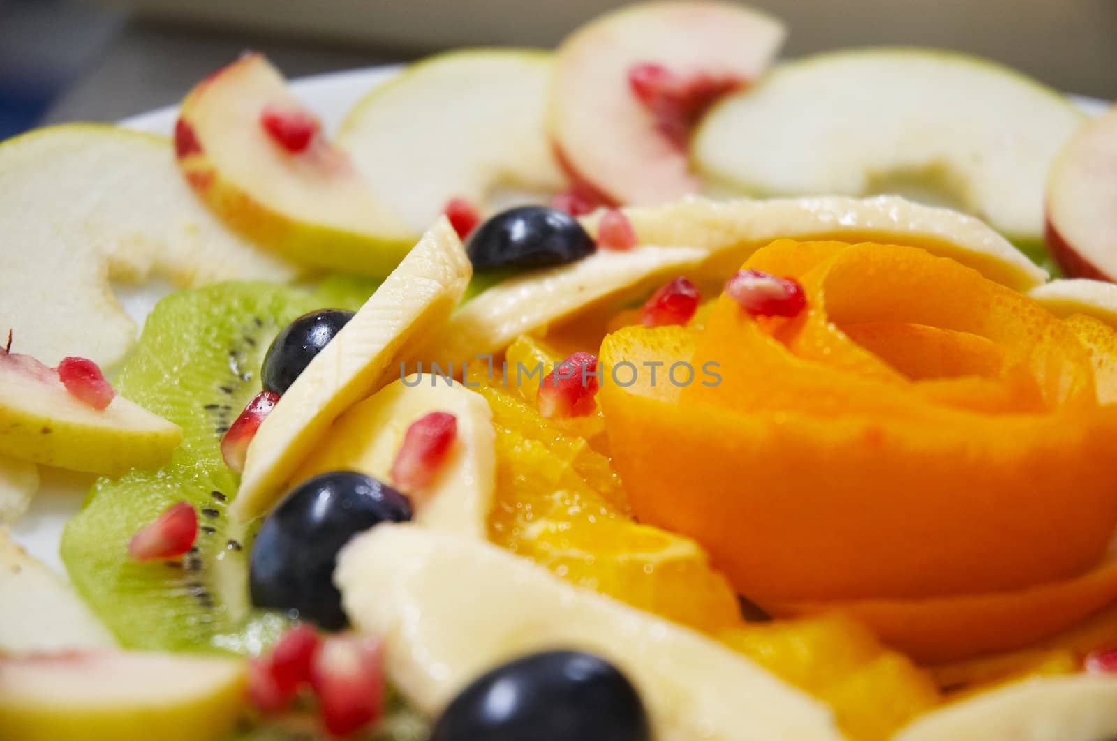 Perfectly designed fresh juicy fruit salad on plate.
Close-up series. Shallow DOF.