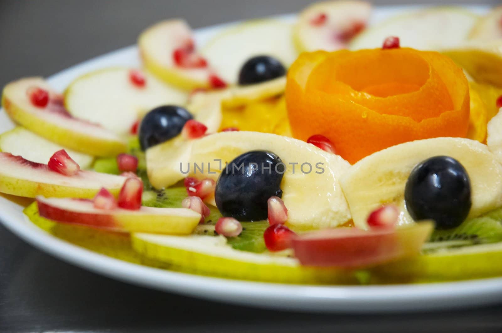 Perfectly designed fresh juicy fruit salad on plate.
Close-up series. Shallow DOF.