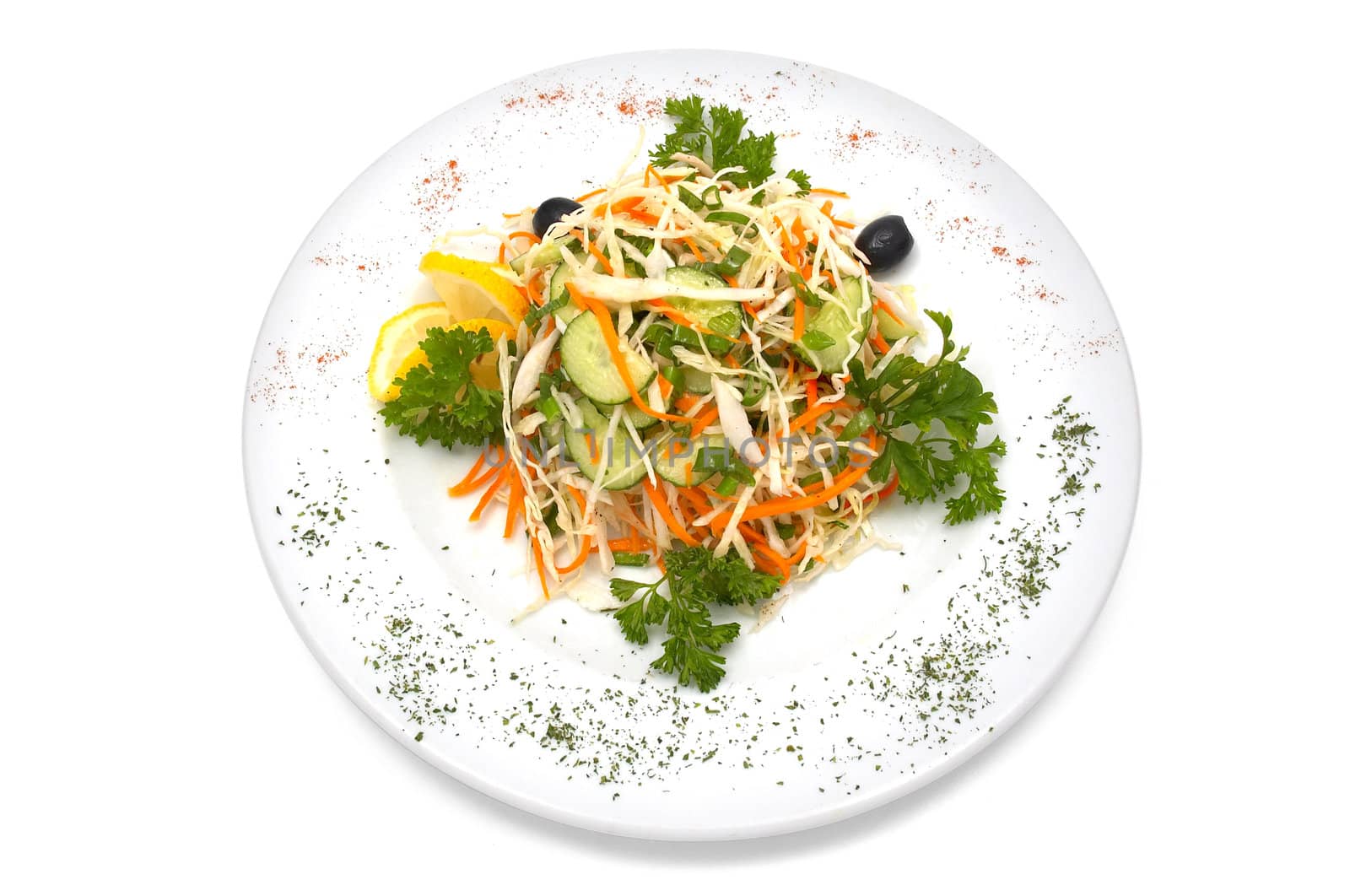 Salad made with fresh cabbage, cucumber, carrot, parsley. Black olives and slice of lemon added.
