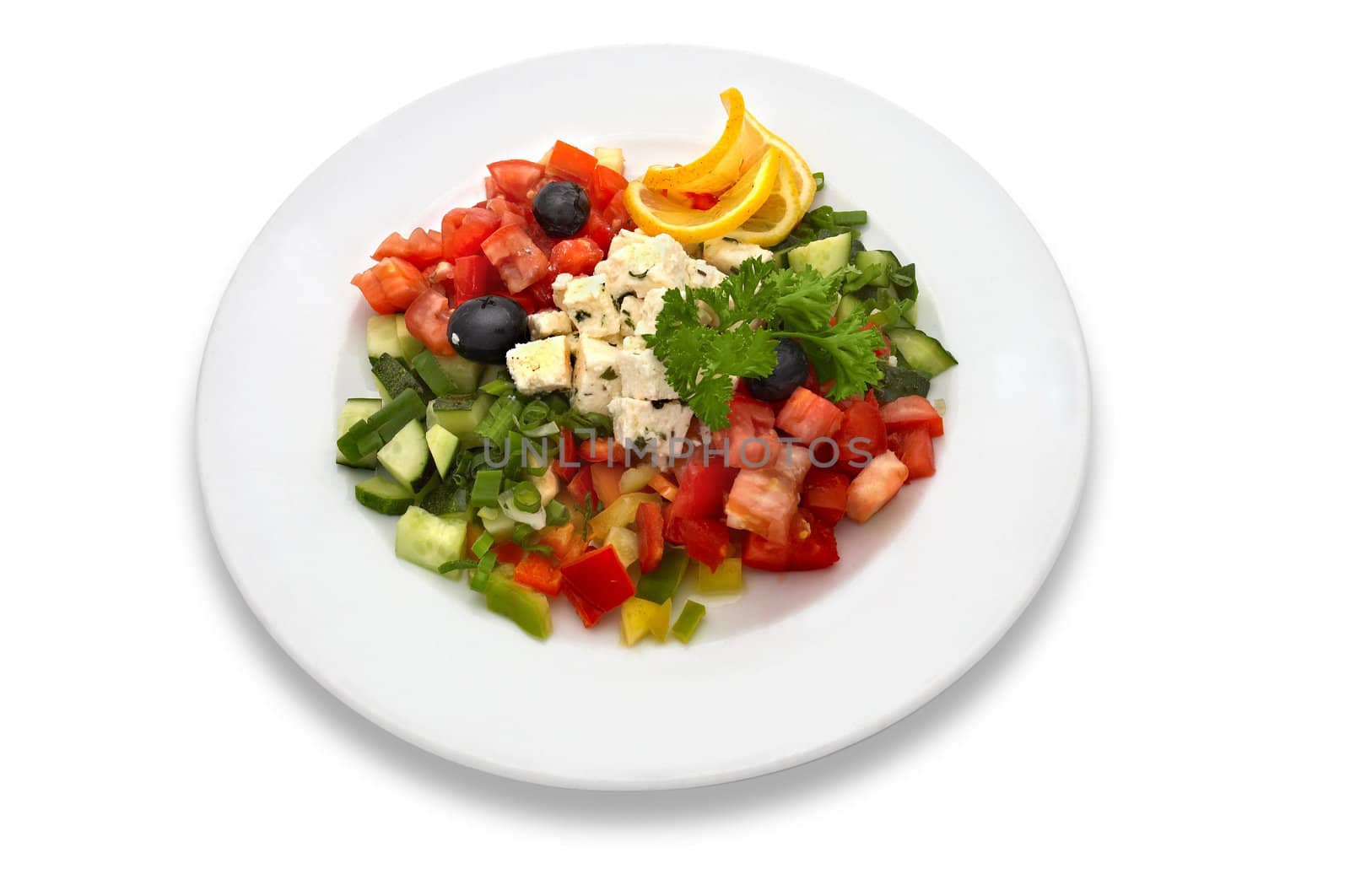 Salad made of fresh tomatoes, feta cheese, cucumbers, red peppers, lemon slices, olives and parsley. 