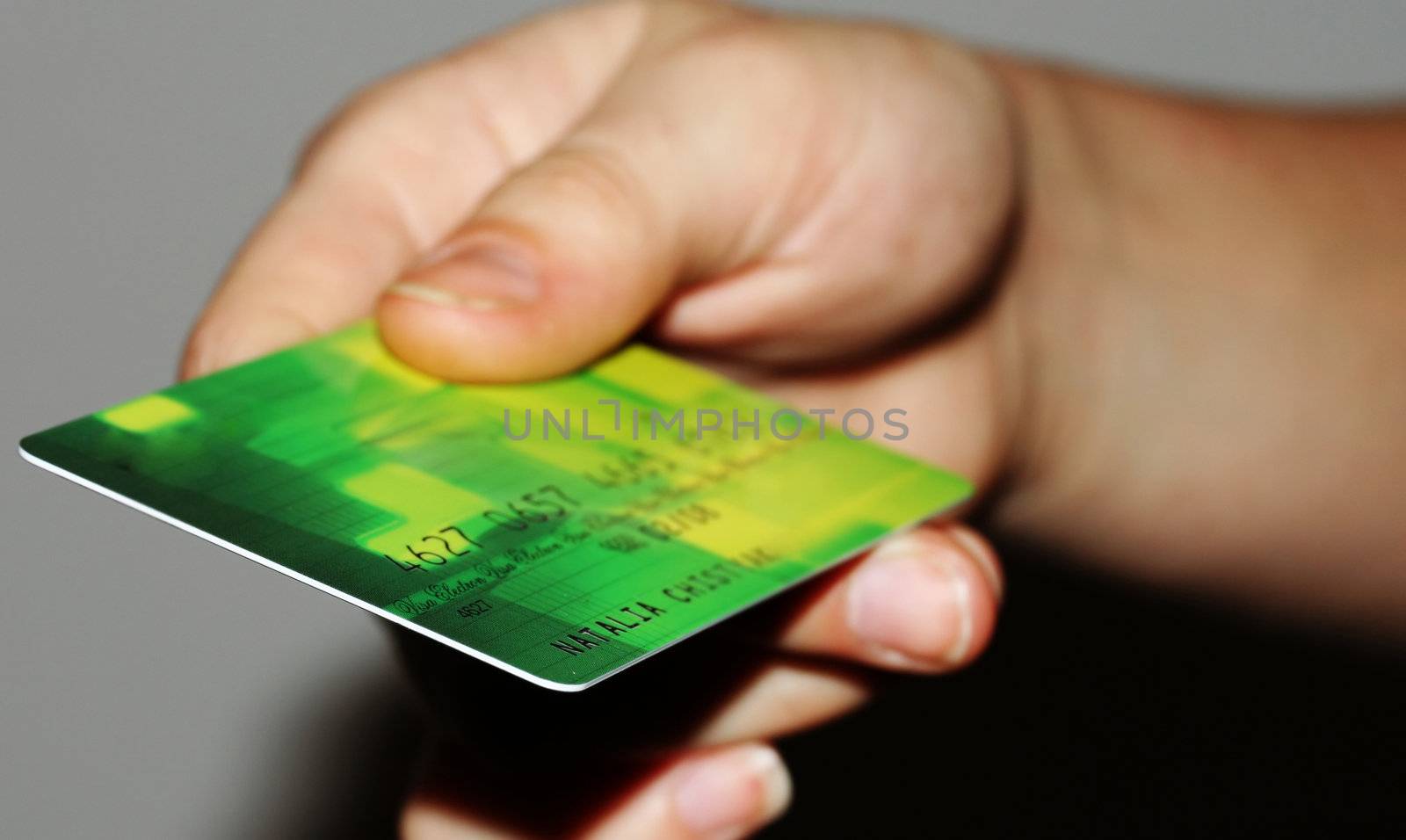 Green credit card close up in a hand