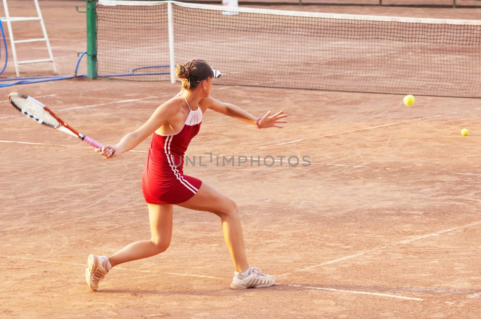 blond girl playing tennis at open court