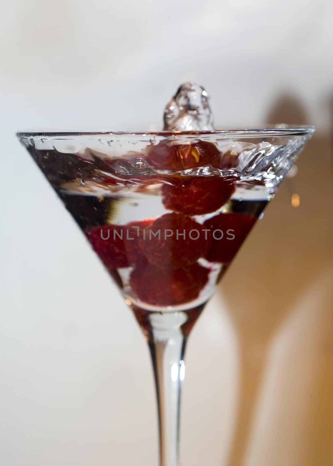 raspberry falling in martini drink