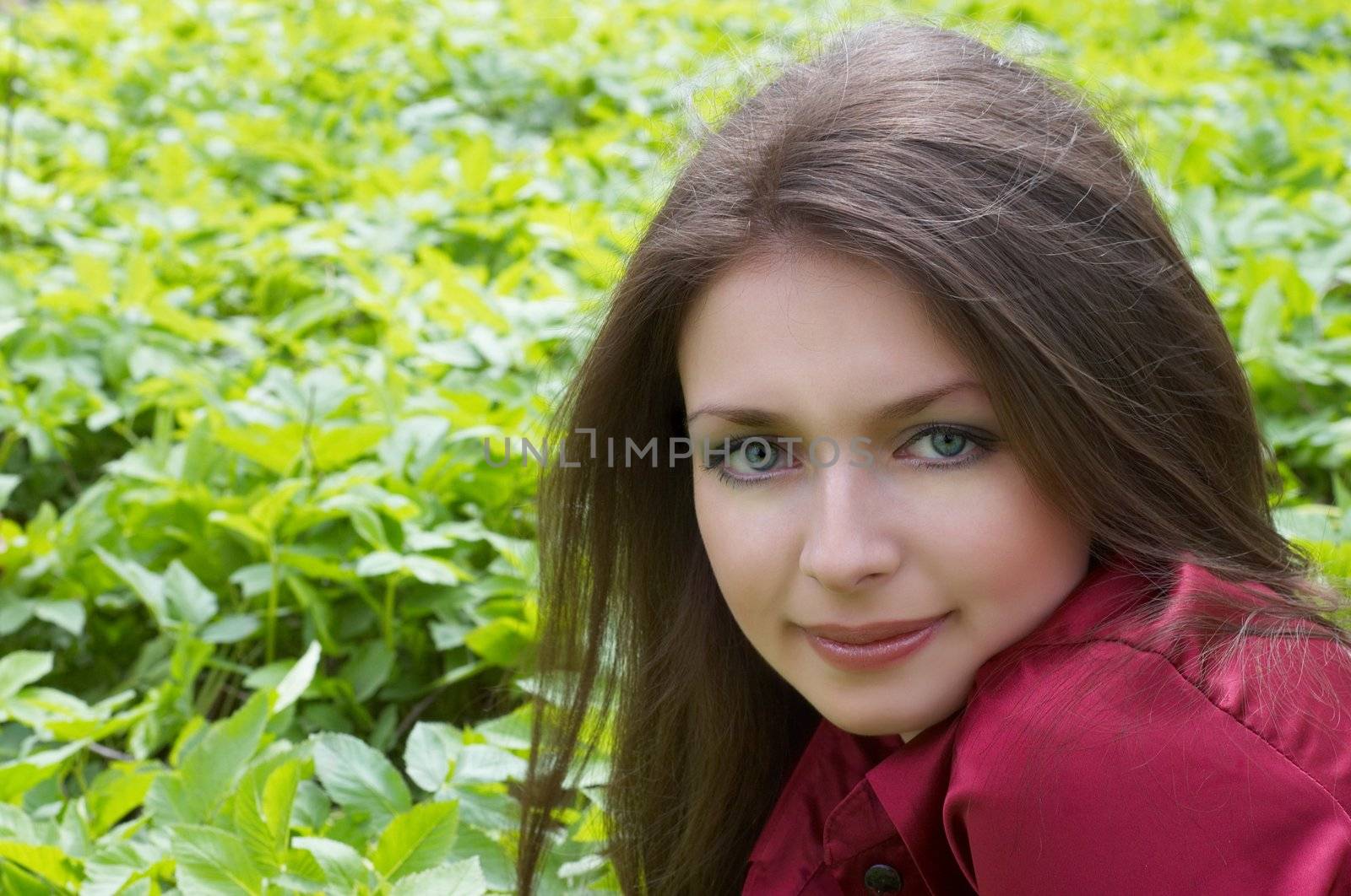 Brunette in red laying on foliage by starush