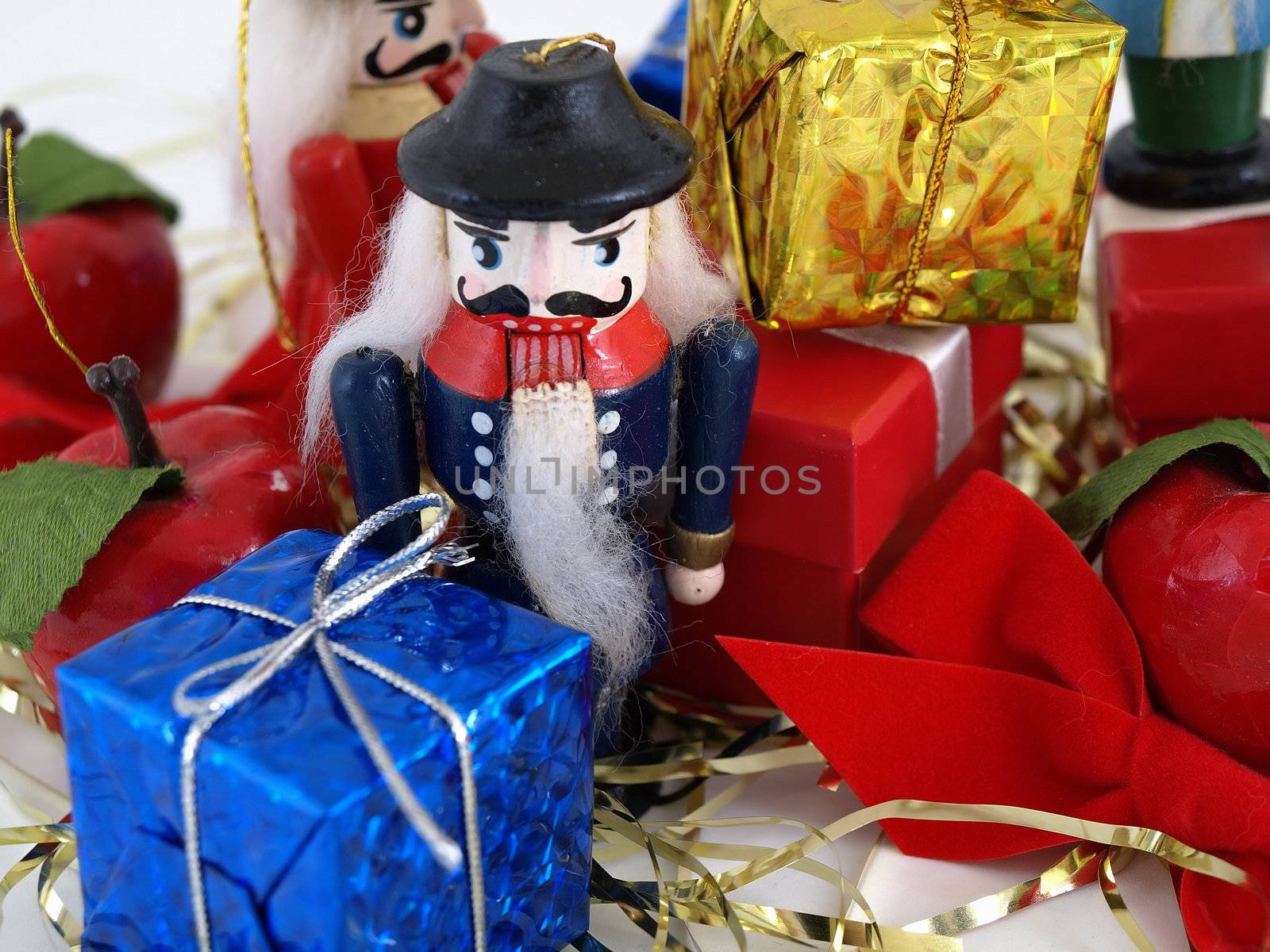 Nutcracker tree ornaments shown with colorful gift boxes. Studio isolated over white.