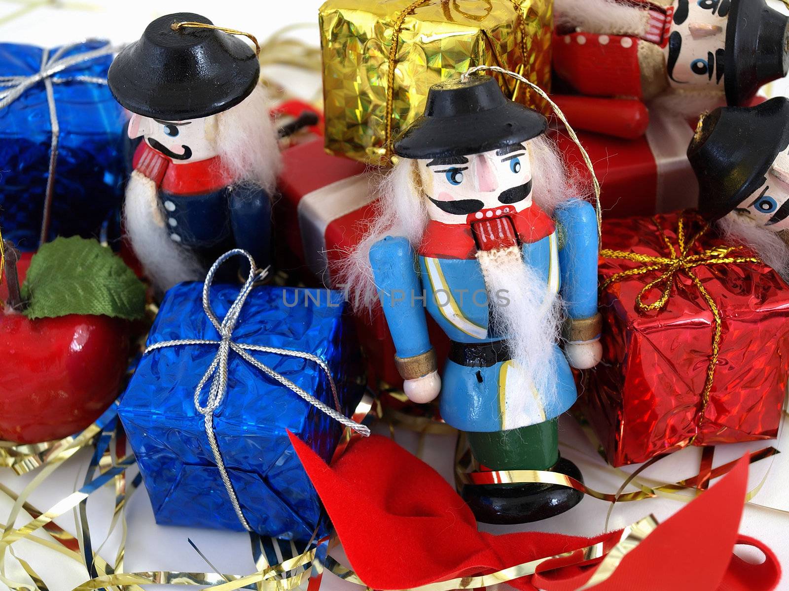 Nutcracker tree ornaments shown with colorful gift boxes. Studio isolated over white.