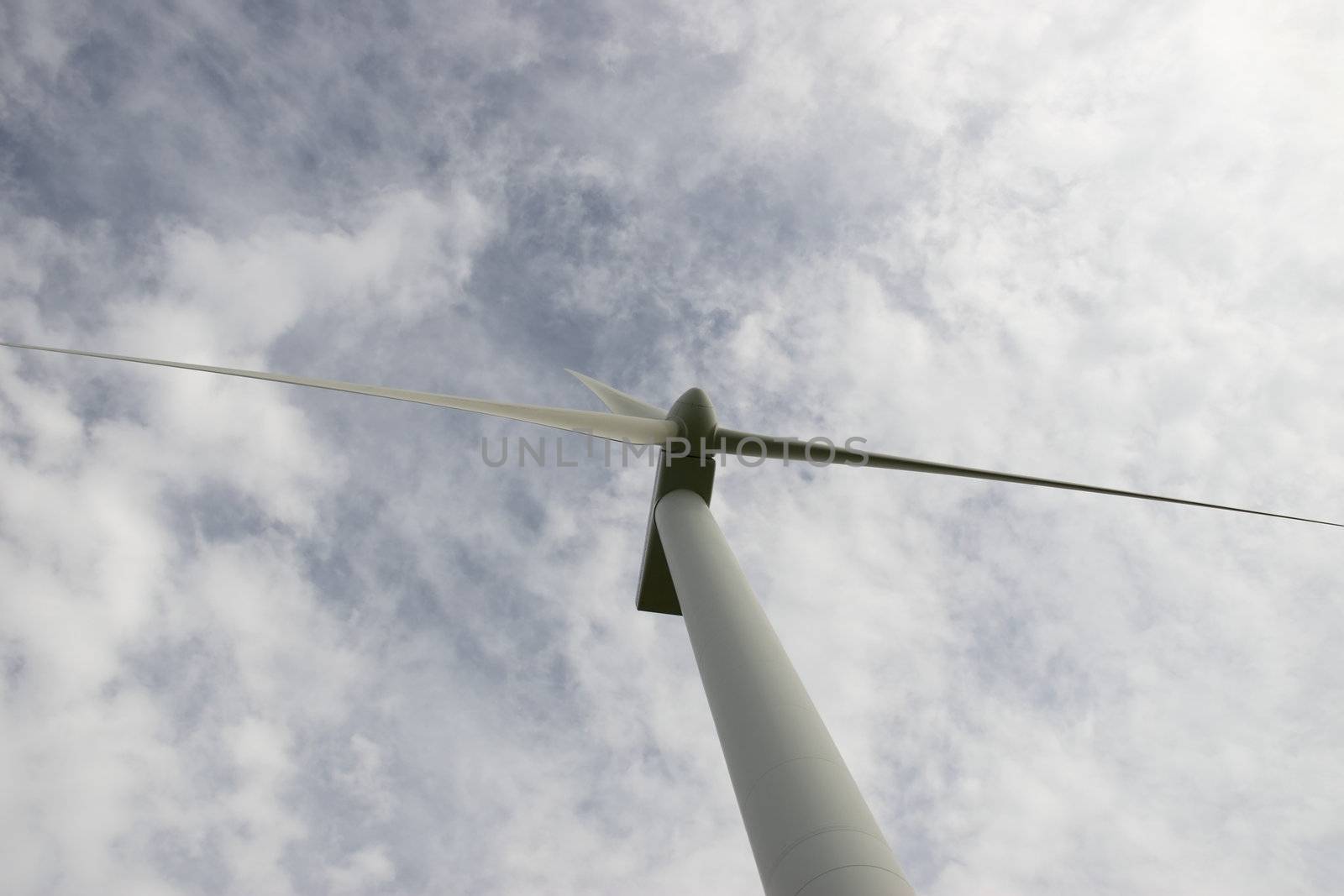 a wind turbine against a calm cloudy sky