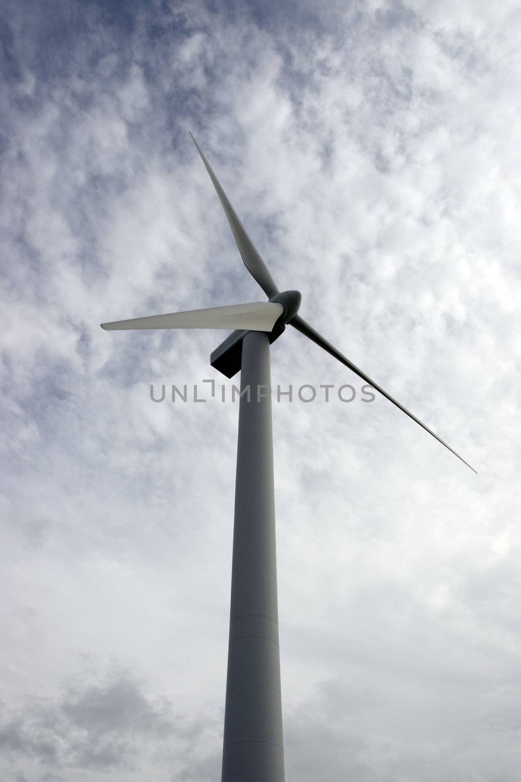 a wind turbine against a calm cloudy sky