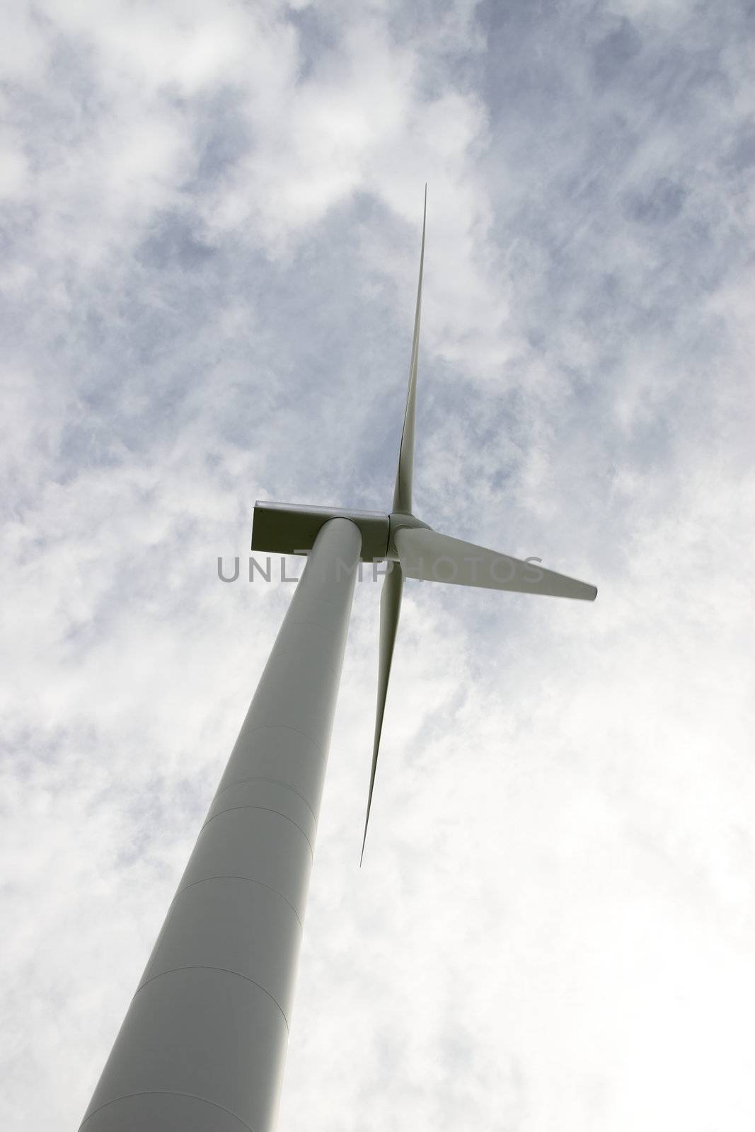 a wind turbine against a calm cloudy sky