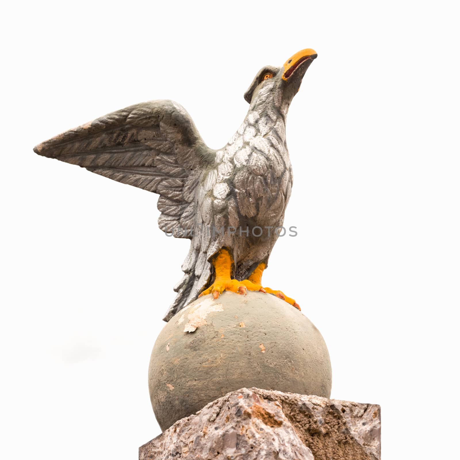 Stone eagle sculpture in powerful pose guarding entrance gate of residence.