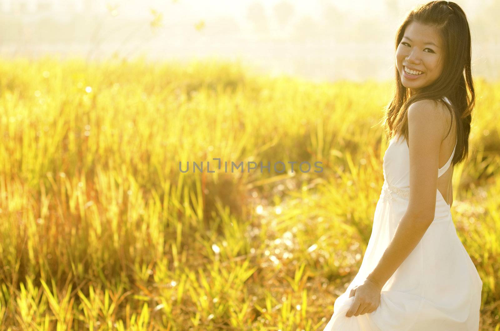 Asian bride at outdoor in a morning surrounding by golden sunlight