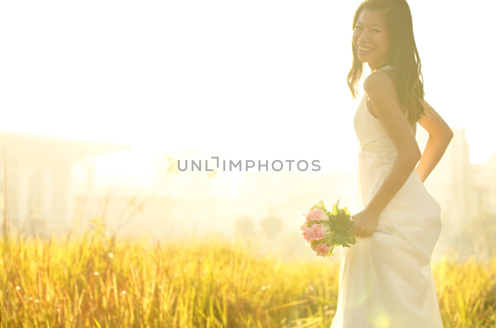 Asian bride at outdoor in a morning surrounding by golden sunlight