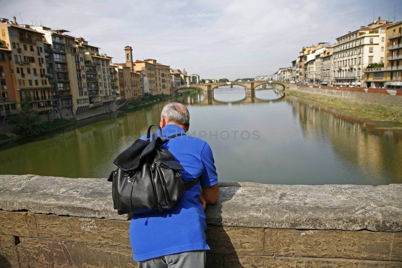 Retired man standig at Ponte Vecchio - Florence - Italy enjoying what he see while he feels the wings of history. 