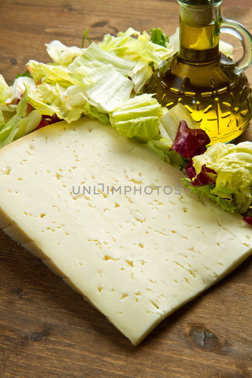 Asiago cheese with fresh salad on wooden table