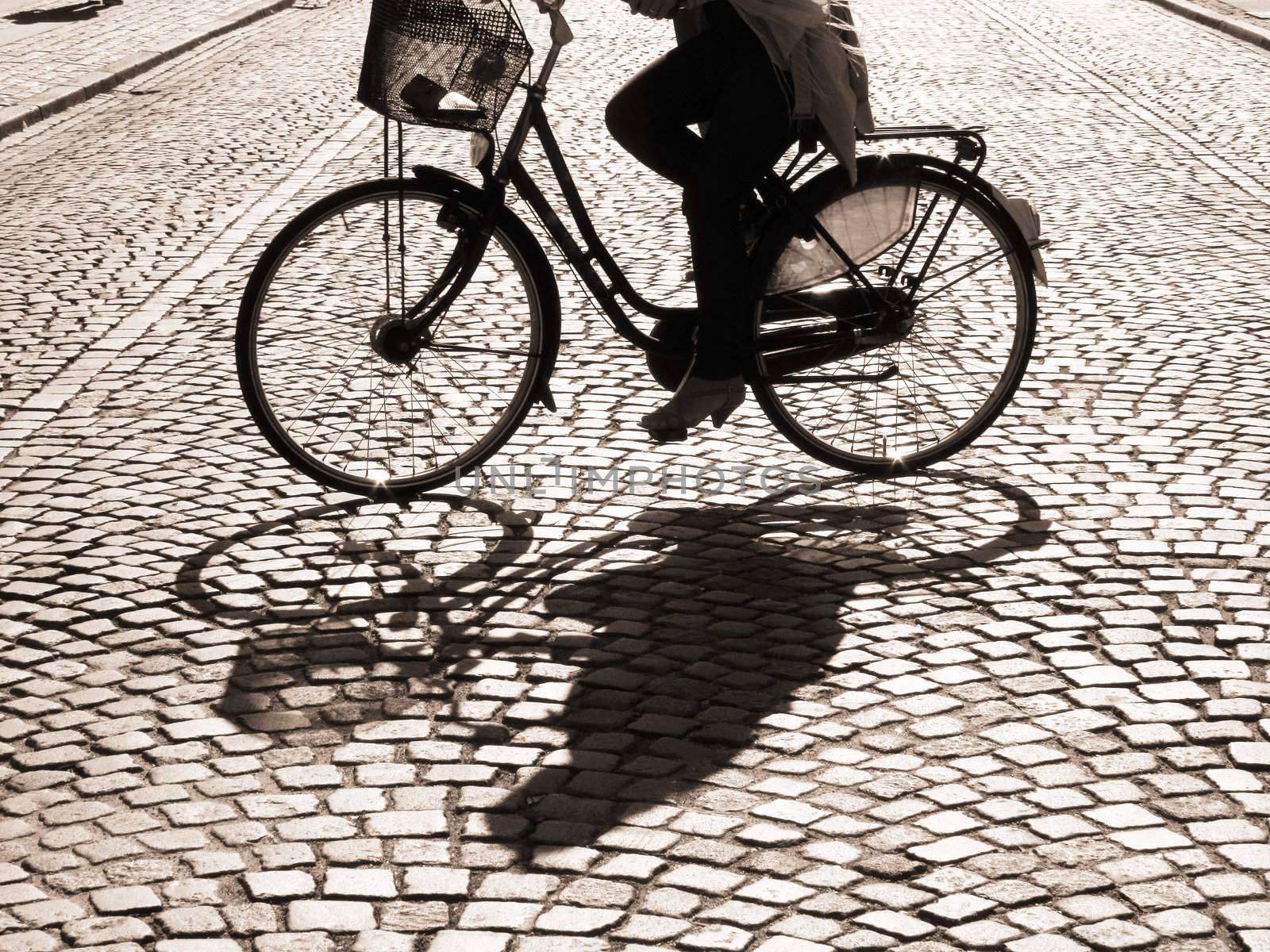  A warm spring afternoon a young girl is biking through the old streets of Copenhagen, Denmark.                      