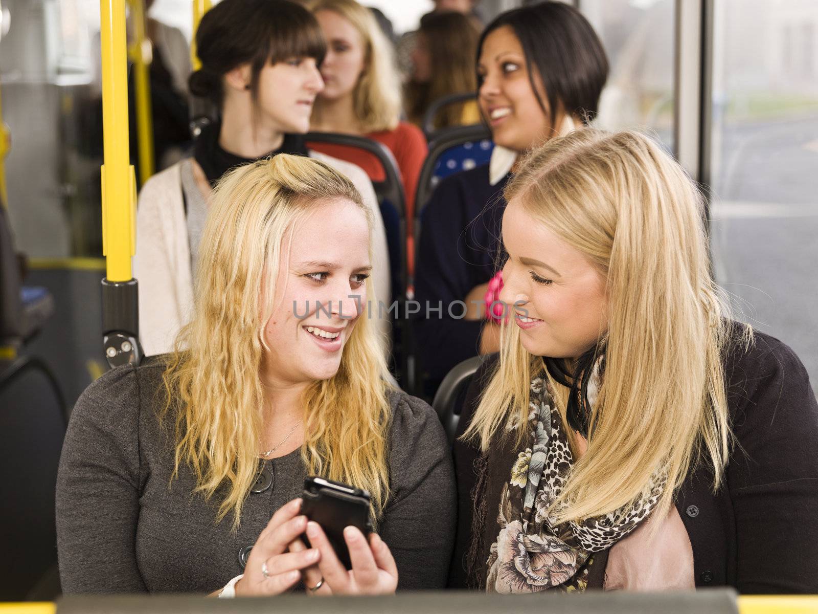 Young woman looking at cellphone while going by the bus