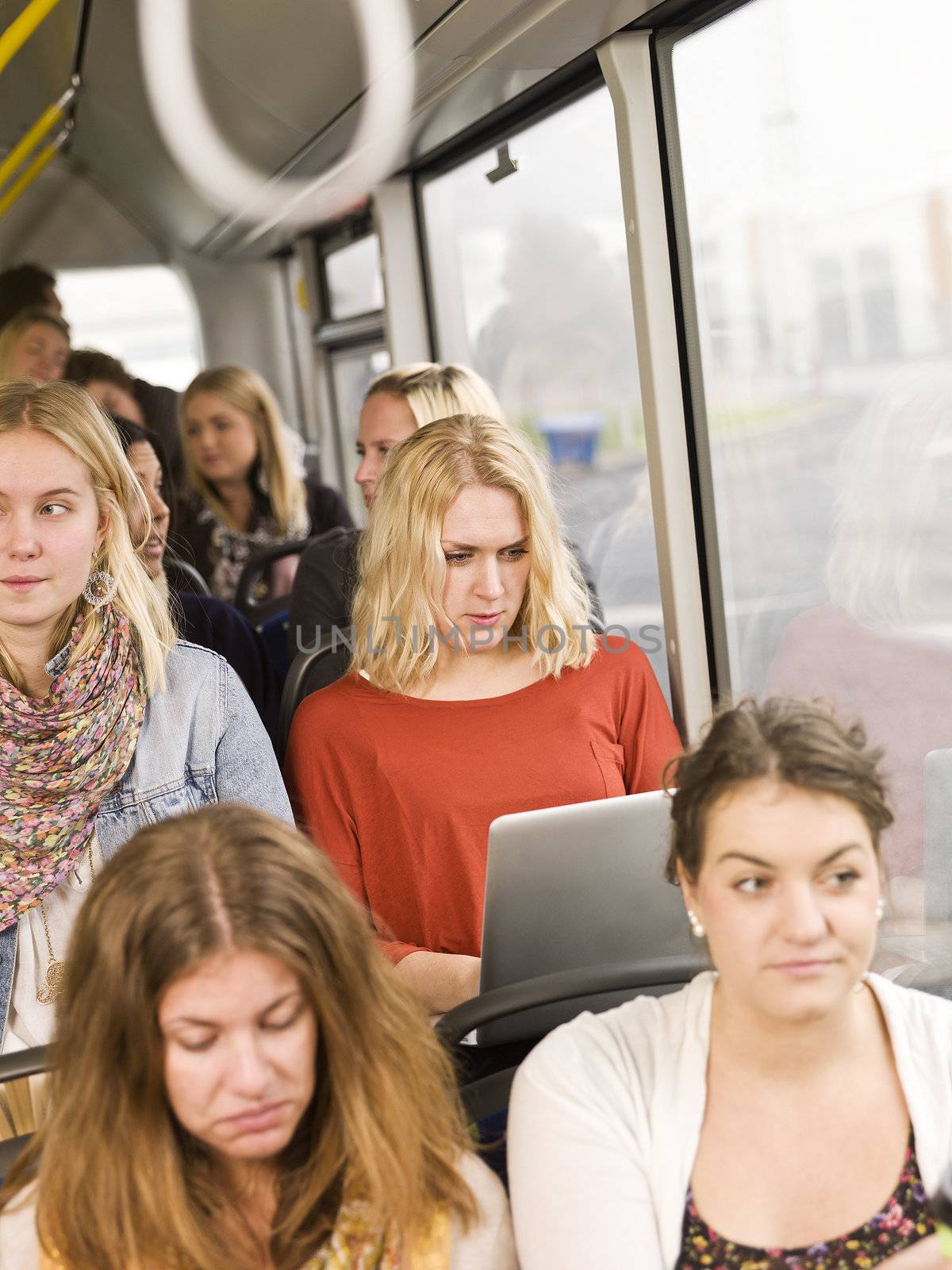 Serious woman on the bus with a computer