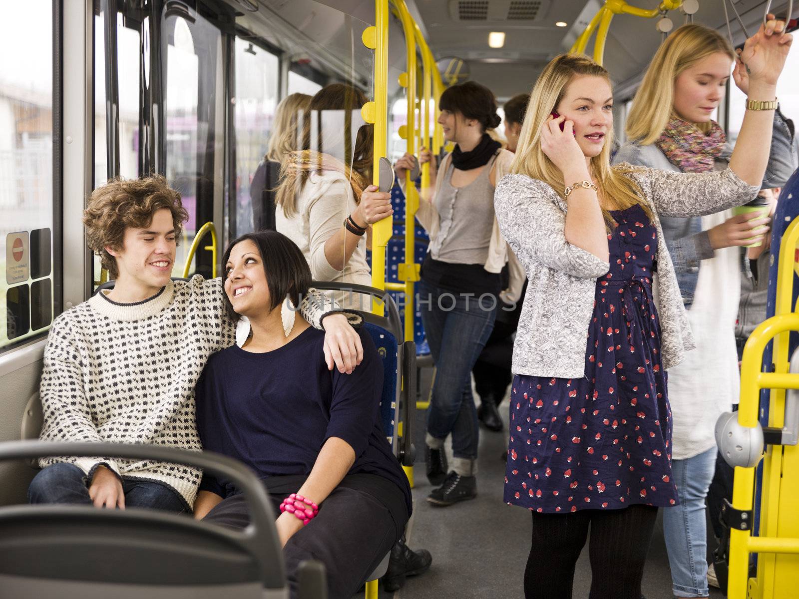 Happy couple going by bus with large group of people