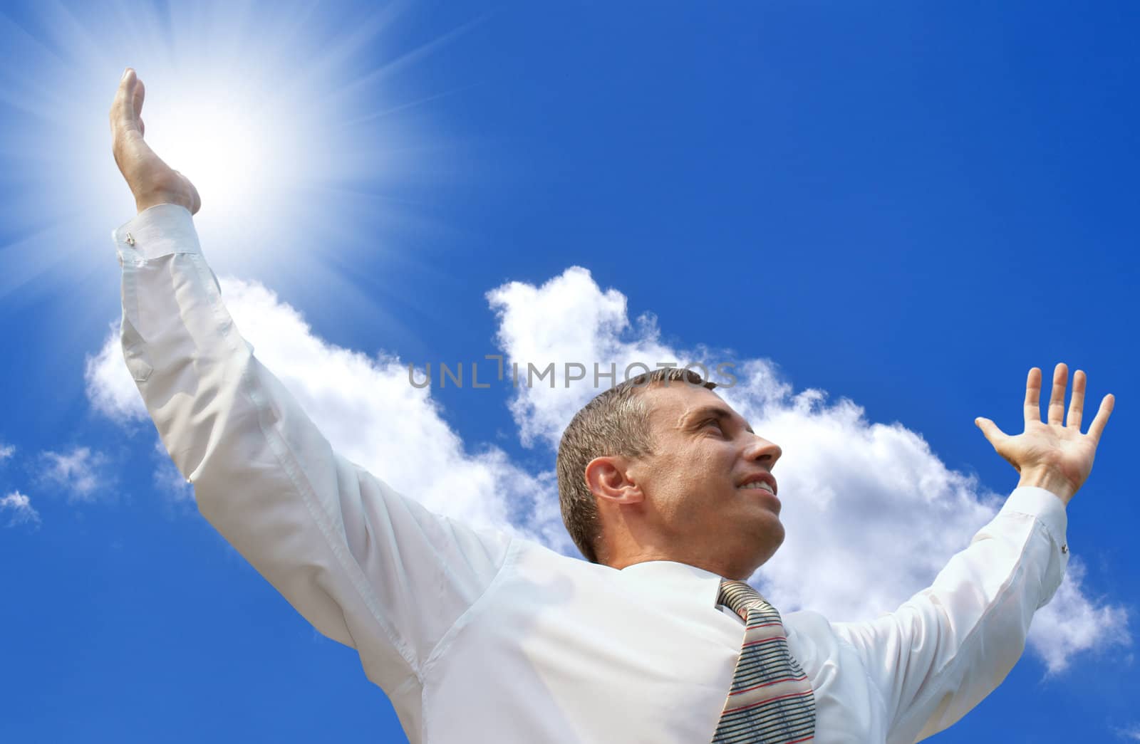 The smiling successful businessman against the blue clear sky