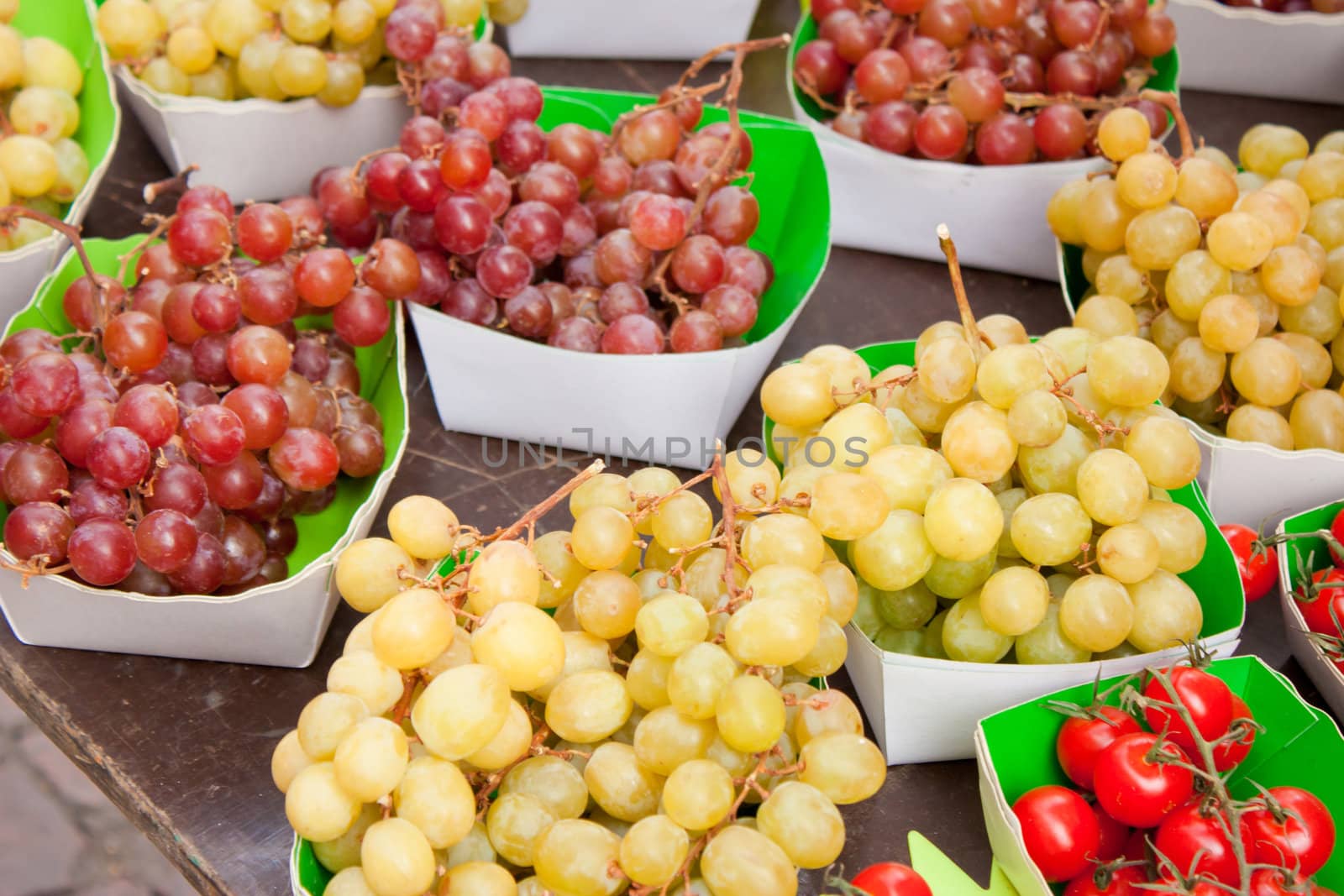 Display in a french market, bunch of grapes, cherry tomatoes