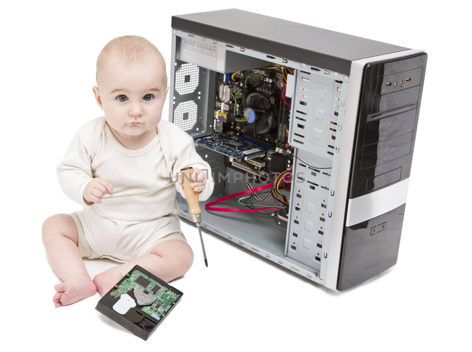 young child with screwdriver in hand working on open computer in white background. hard disk laying around