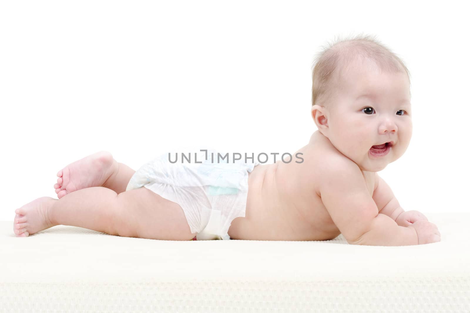 Five months old baby girl happy crawling on bed