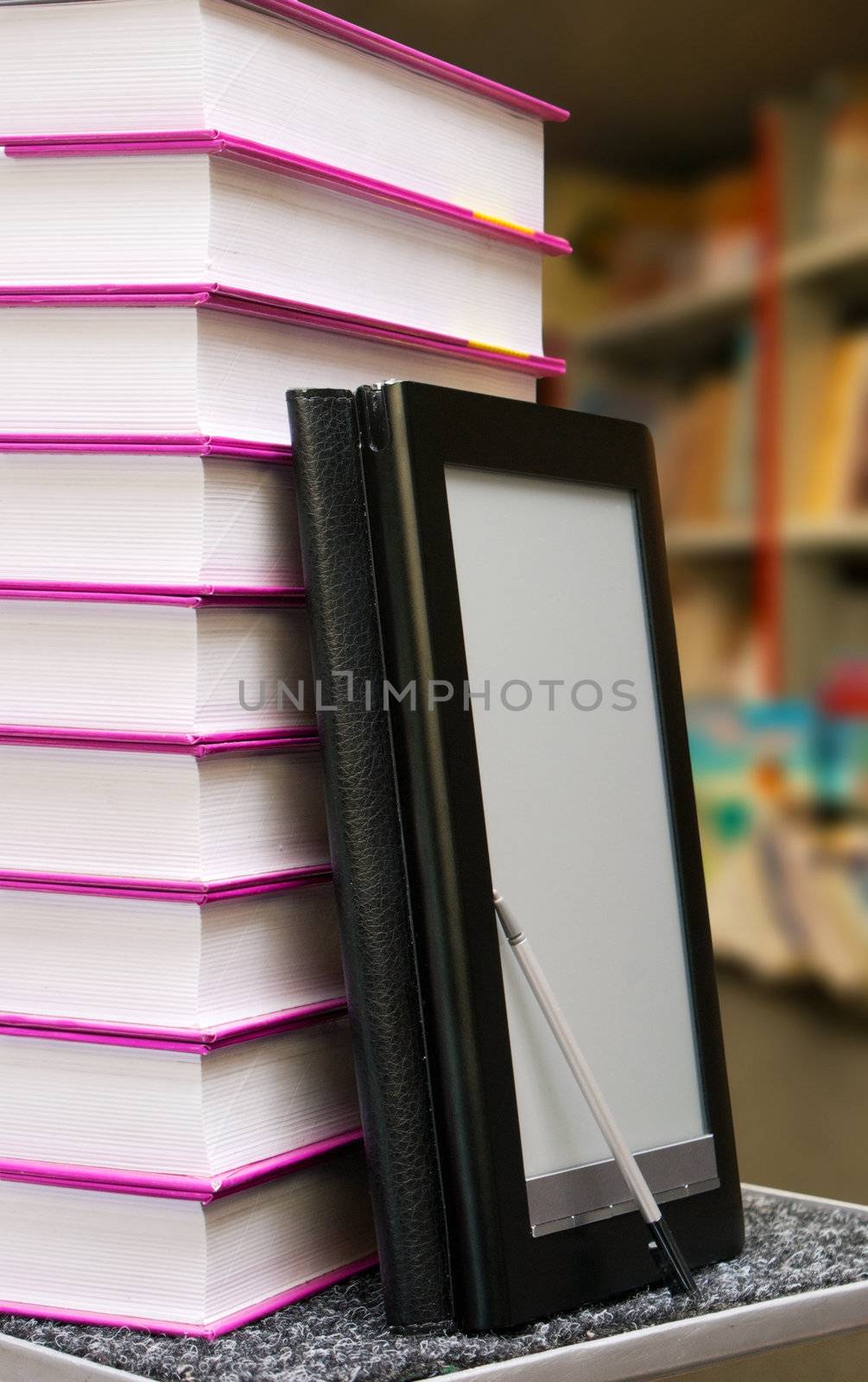 Stack of books with electronic book reader