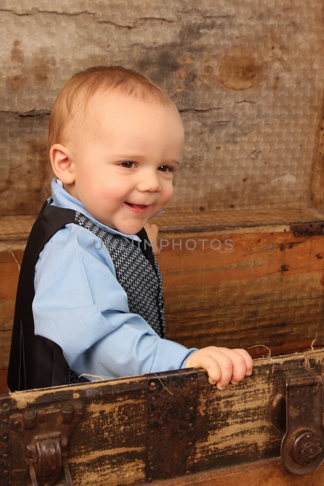 Baby boy playing inside an antique trunk