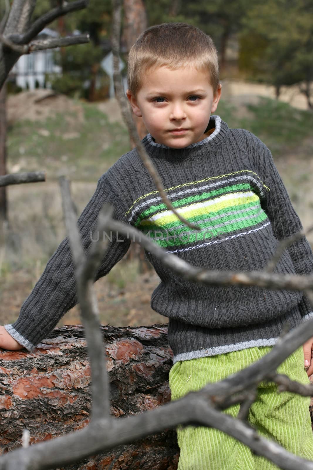 Little blond boy playing outside in the field