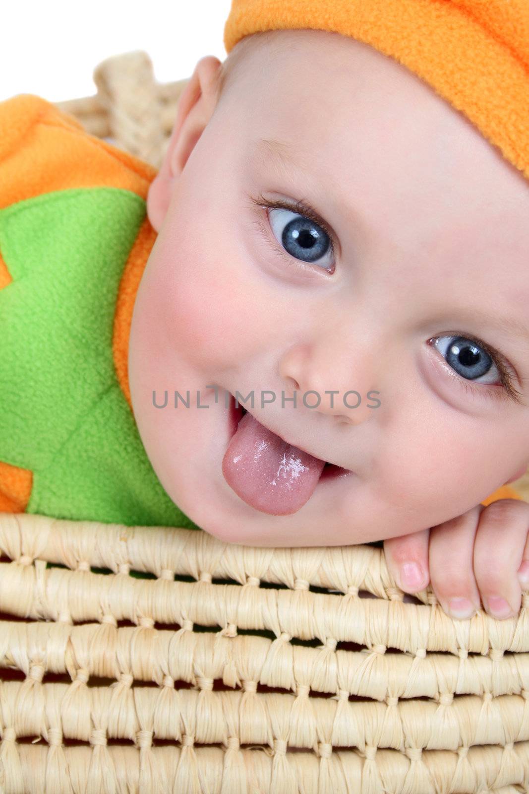 Baby boy wearing a pumpkin costume in a basket