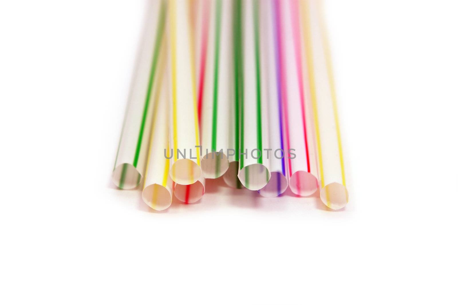 many multicolor straws close up on white
