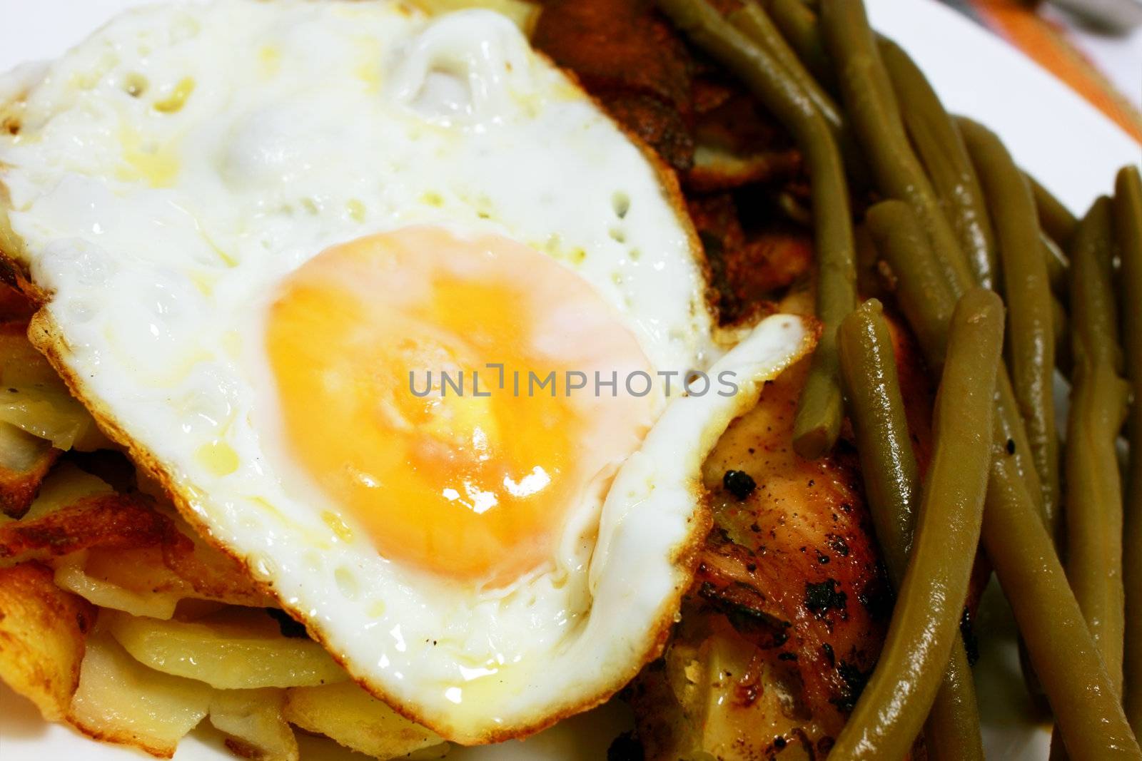 scrambled egg, bean pods and fried potatoes close up