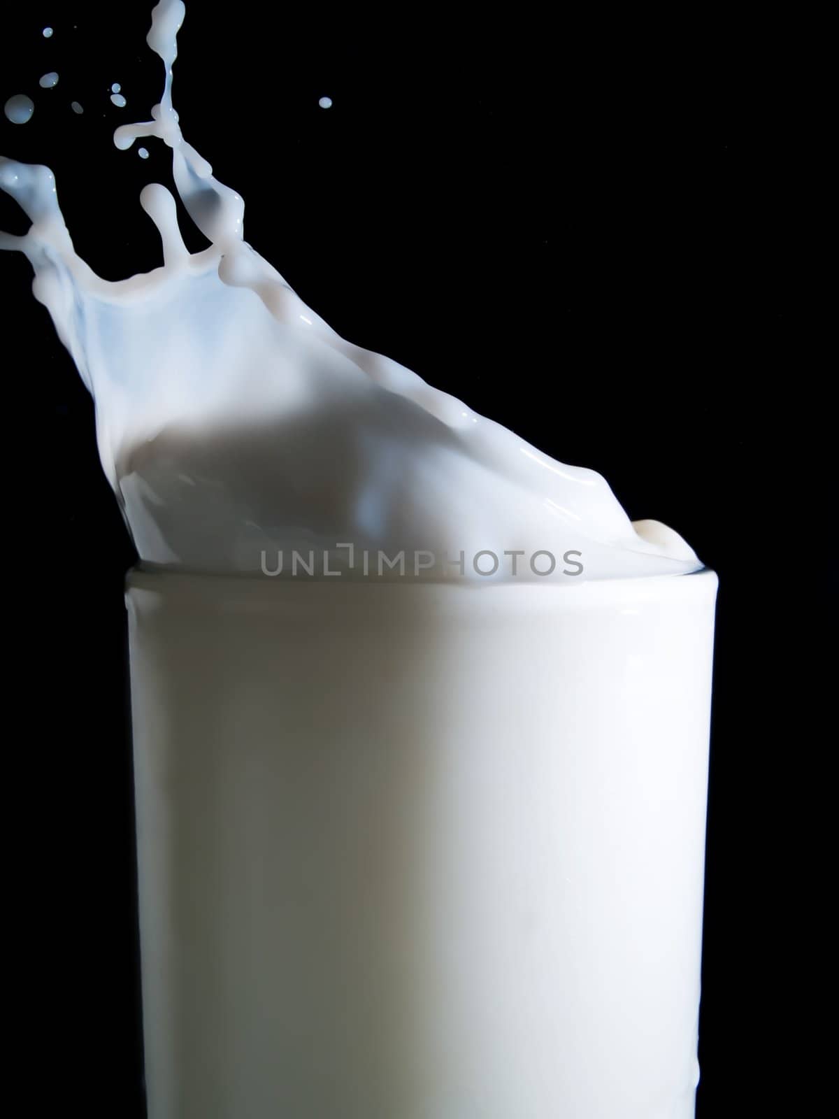 Glass of milk on a black background