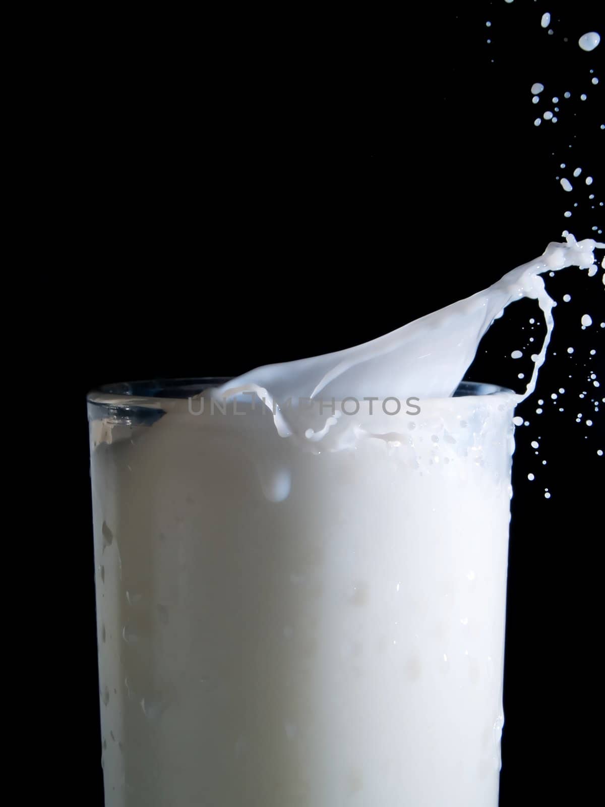 Glass of milk on a black background