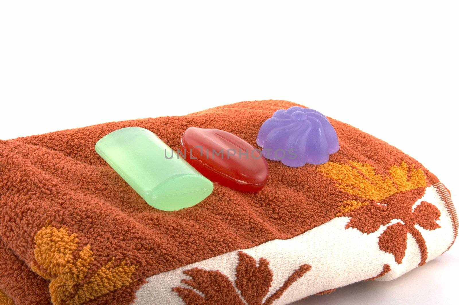 Set from three grades of translucent soap laying on a brown terry towel