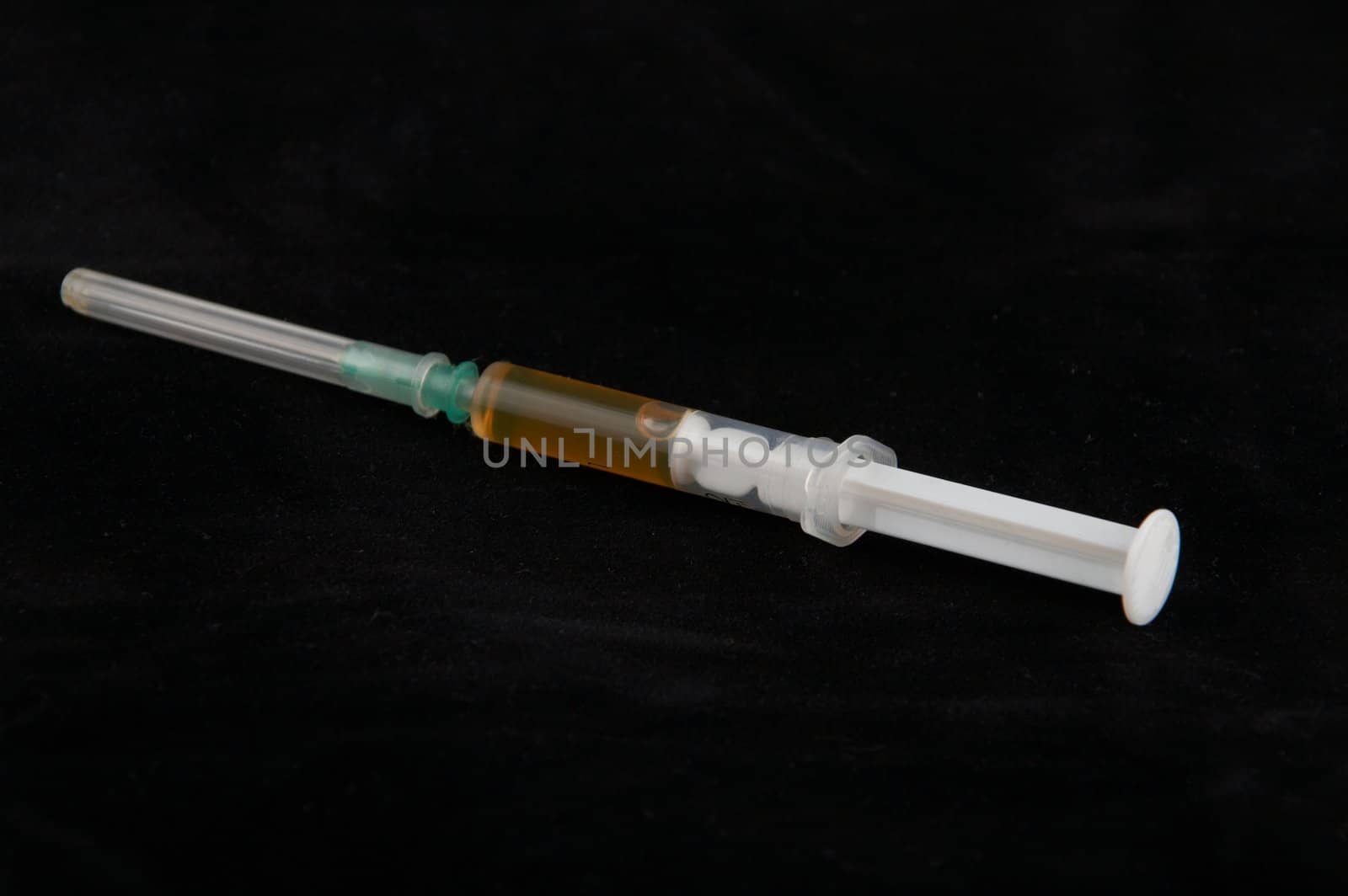 The filled syringe on a black background